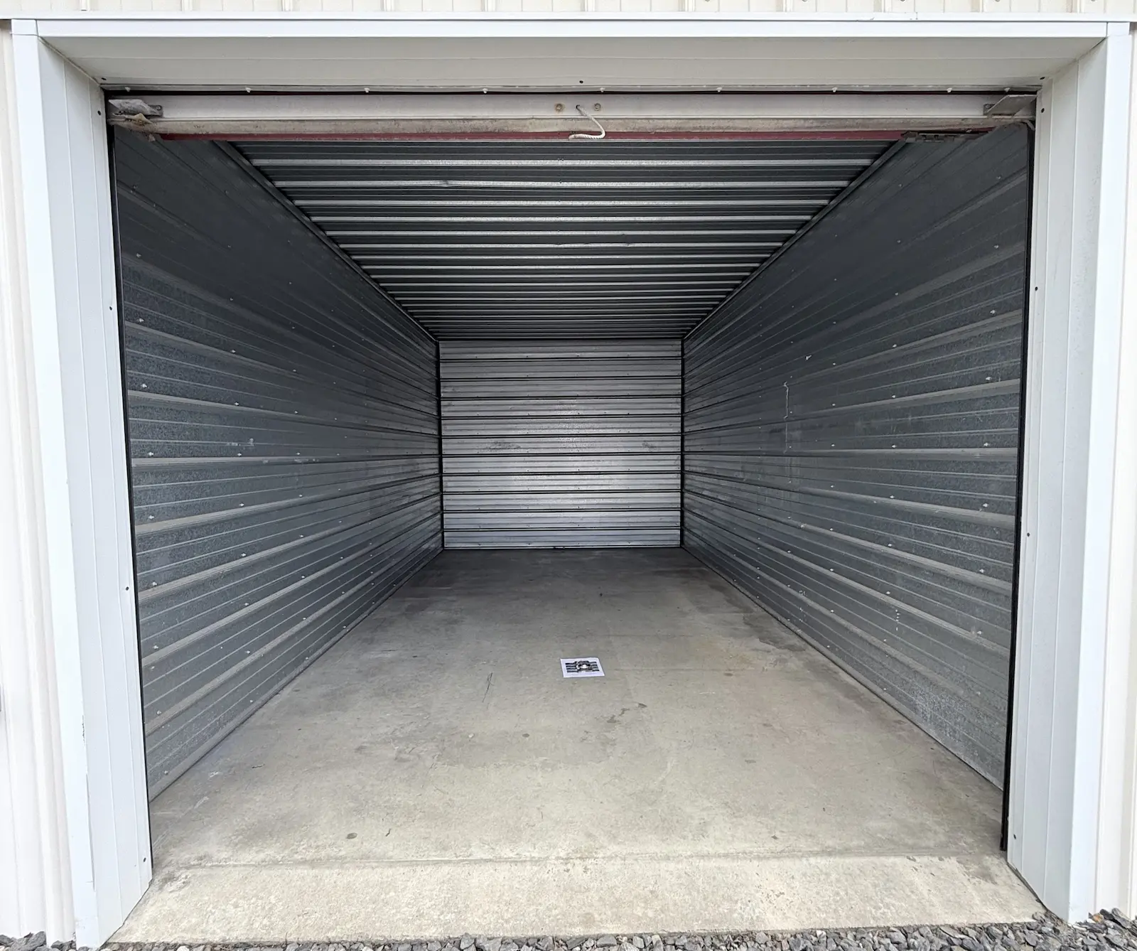 Interior of a 10x20 residential storage unit in Scranton with wooden shelving frame and horizontal metal storage slats, concrete floor, and clear space for personal items